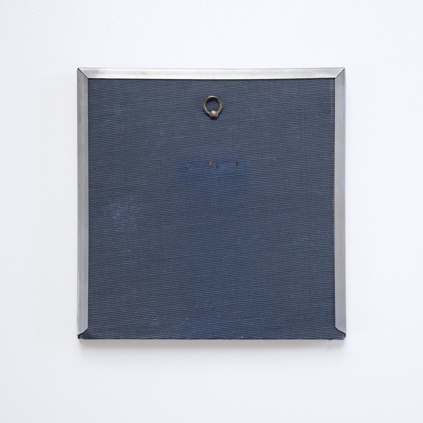 Back of recycled frame with small metal loop for hanging.