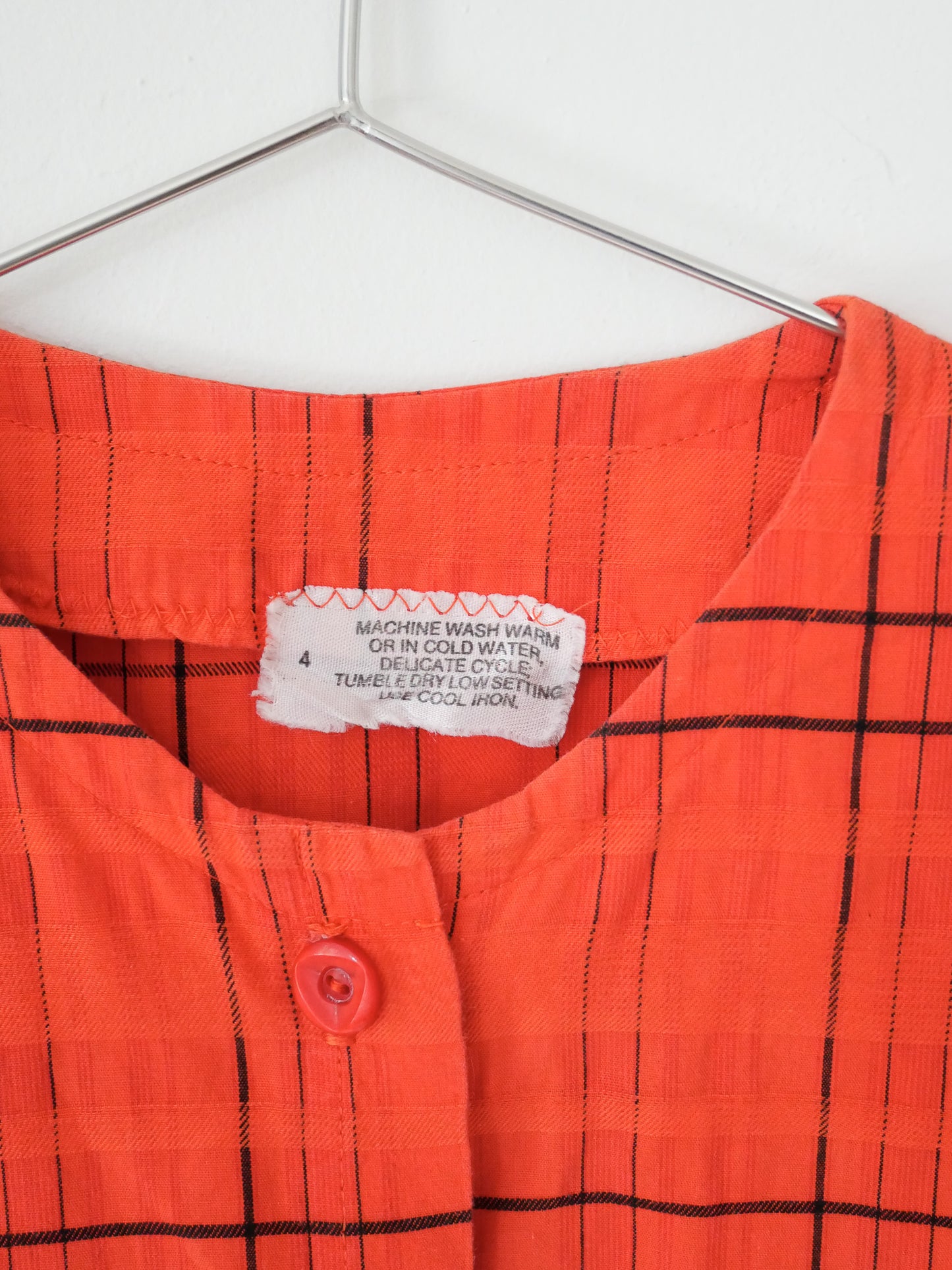 Detail of tag on red orange upcycled crop top