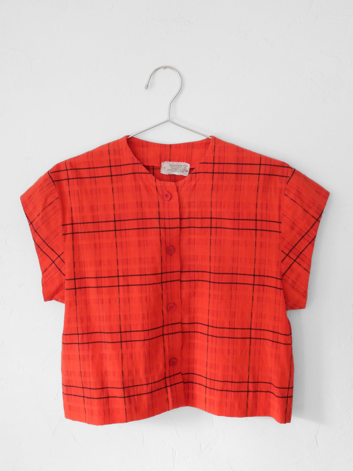 Red orange upcycled crop top on hanger on white background